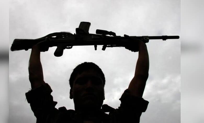 Silhouette of a person holding a rifle against cloudy sky, symbolising violence in Jharkhand.