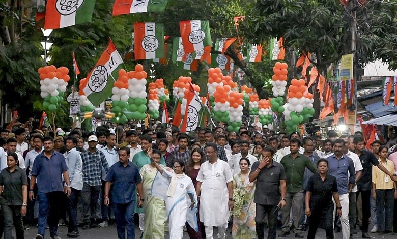 Crowd of supporters at a political rally with BJP flags and orange, white, green balloons in India.