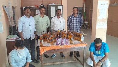 Community members displaying bottles of hand sanitiser at an indoor event for health awareness.