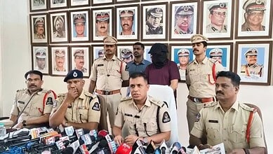 Police officers in Hyderabad hold a press conference after arresting a sales manager involved in a Rs 3 c.