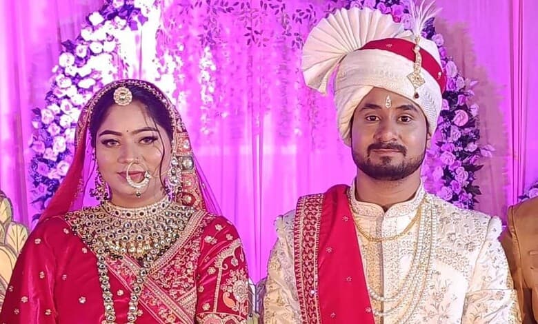 Sonam Raghuvanshi in wedding dress with her husband at a colourful Indian wedding.