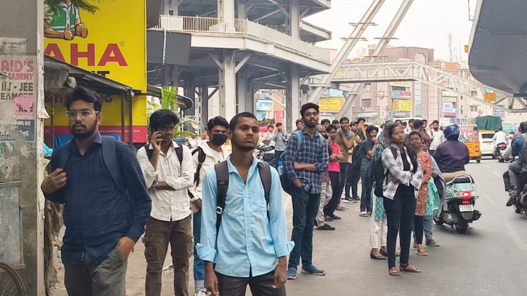 People waiting in line at bus stops during Telangana TGSRTC workers' strike.