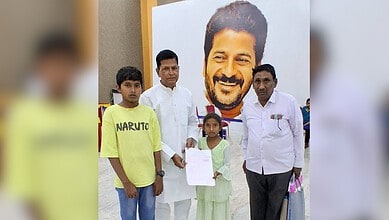 This image shows a family in Hyderabad holding a birth certificate, with a large portrait in the background.
