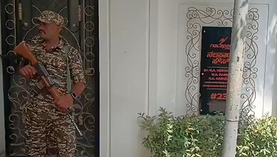 Security personnel with a rifle outside a building in Karnataka.