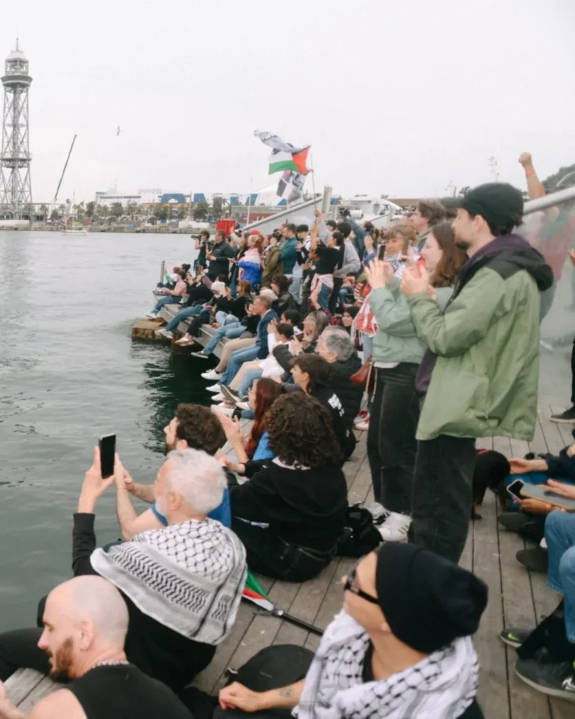 Crowd gathers along waterfront in Barcelona to see off Gaza-bound flotilla.