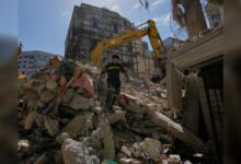 Lebanese civil defence worker walks over rubble after Israeli airstrike in Beirut.