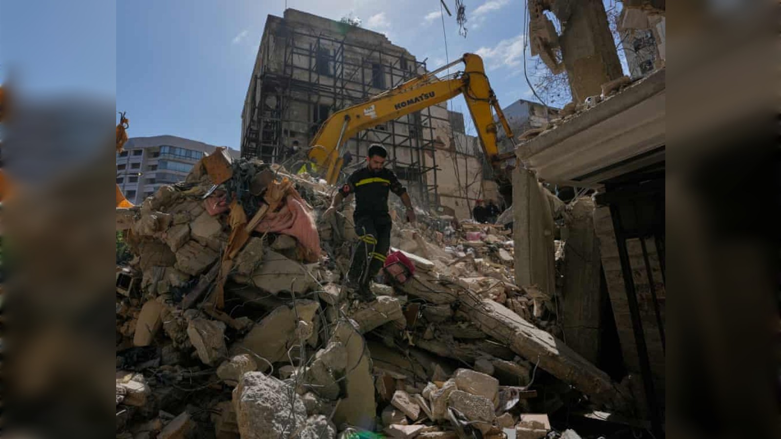Lebanese civil defence worker walks over rubble after Israeli airstrike in Beirut.