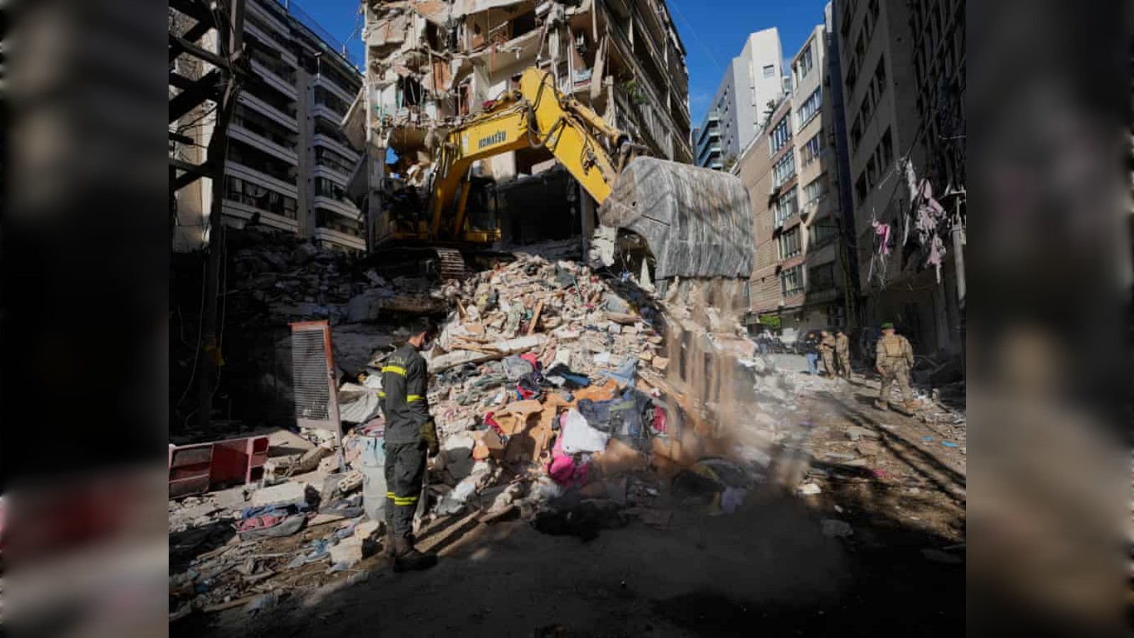 Excavator clearing debris at damaged building after strikes in Beirut