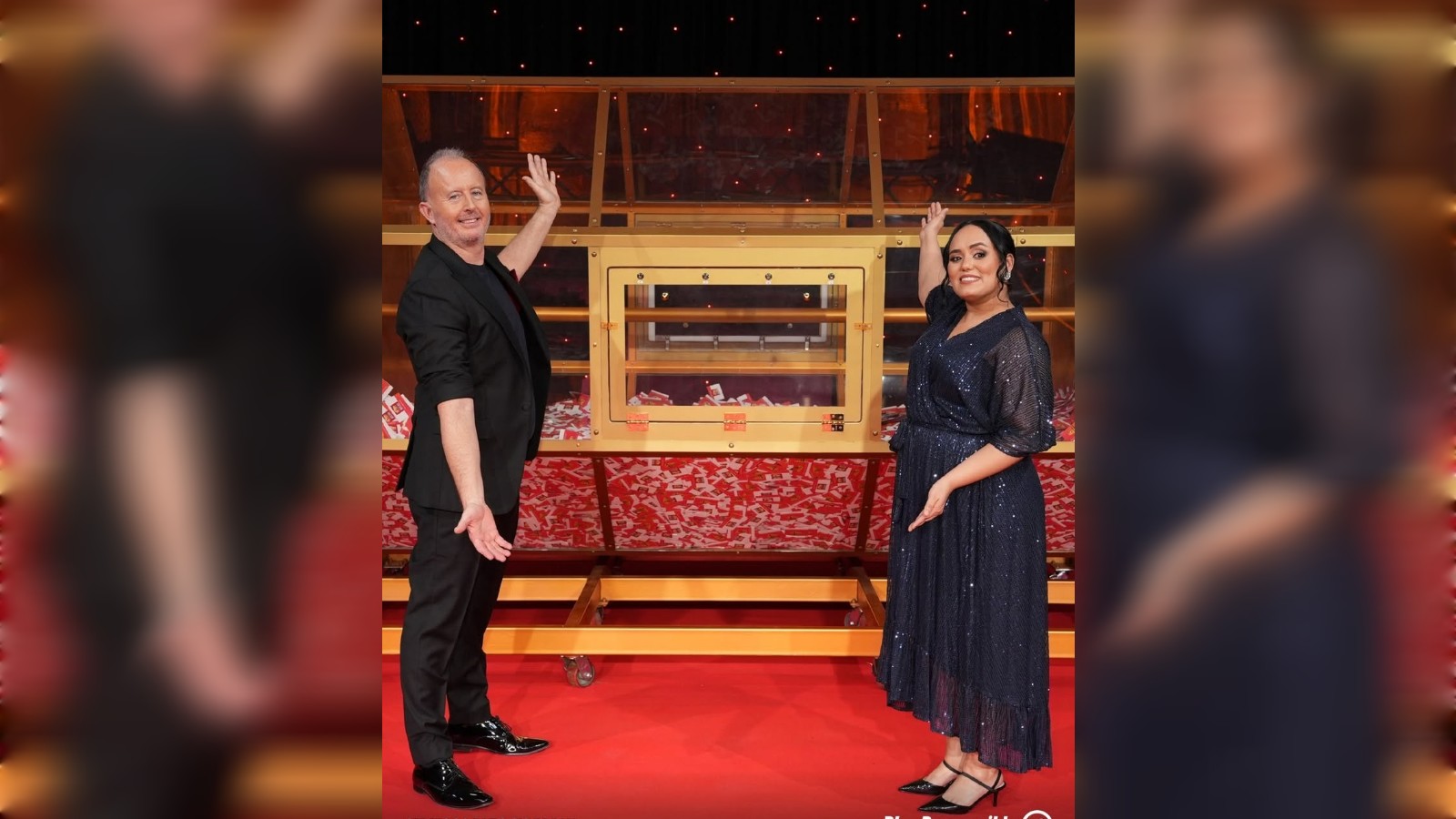 Big Ticket Abu Dhabi hosts Richard and Bouchra Yamani stand beside the raffle draw machine on stage.