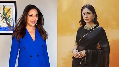 Mrunal Thakur smiling in a blue outfit at a media event.