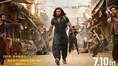 An intense scene with Ranveer Singh as Dhurandhar leading a group in a chaotic street setting.