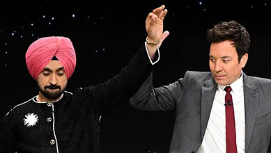 Diljit Dosanjh and Jimmy Fallon dance bhangra during a lively performance on stage.