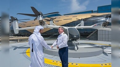 Two men shaking hands in front of a futuristic air taxi at Dubai’s new station.