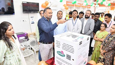 Man demonstrating e-waste recycling to community members at GHMC event.
