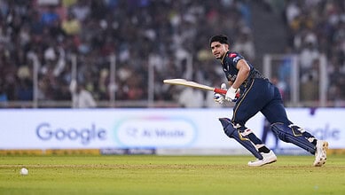 Gujarat Titans cricket player running with bat during match against Kolkata Knight Riders.