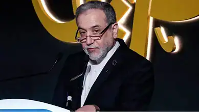 Iran Foreign Minister Abbas Araghchi speaks at a podium during an event.