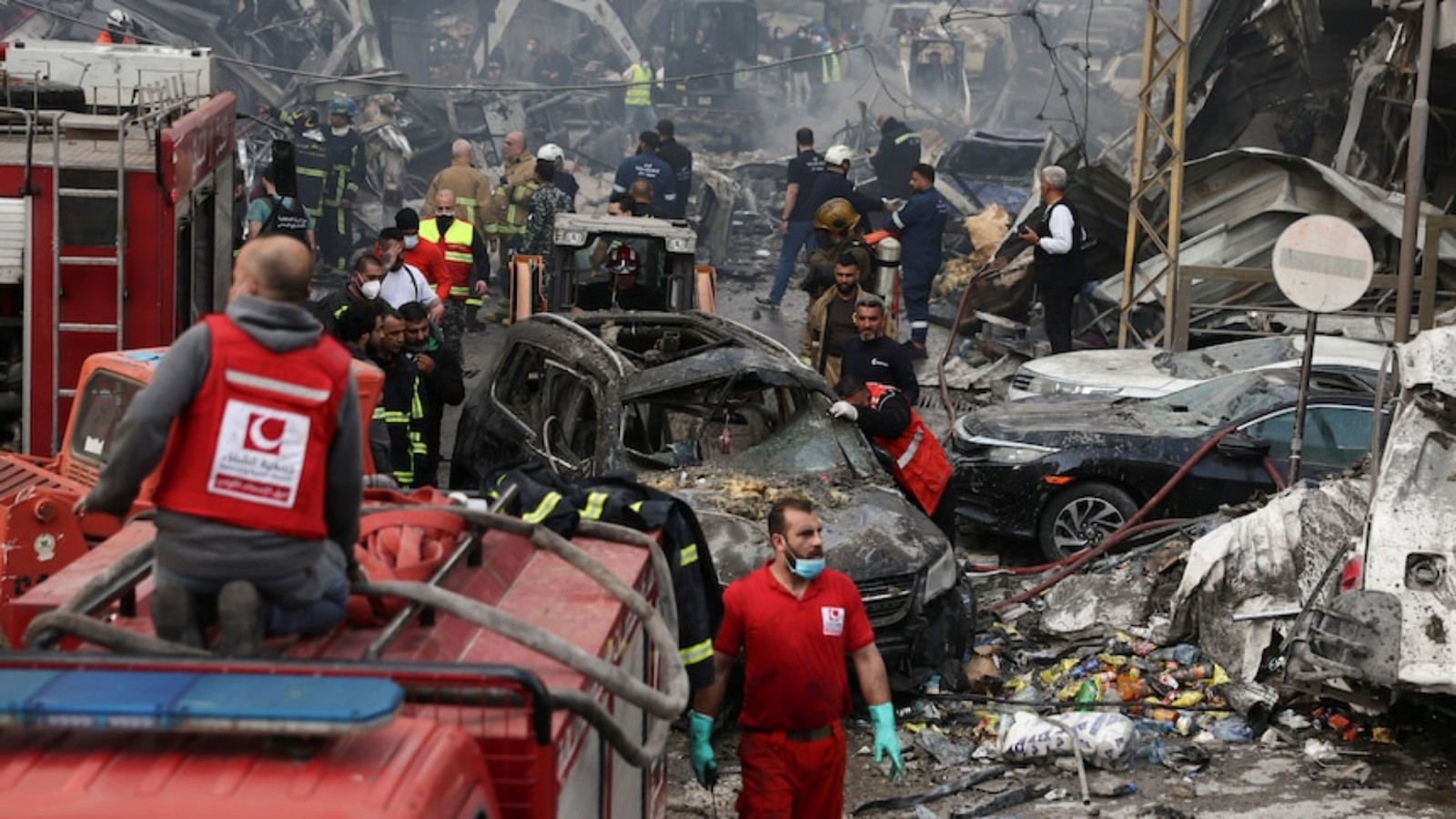 Emergency responders search through rubble and damaged vehicles after an Israeli strike in Al-Mazraa, Beirut.