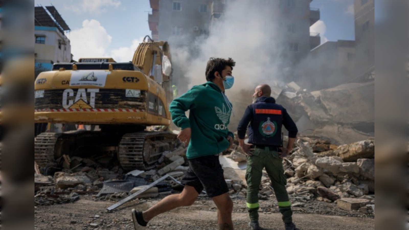 Boy runs past rubble and rescue workers at site of Israeli strike in Tyre, Lebanon.
