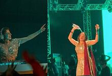 Jasmine Sandlas on stage, dancing and singing passionately during a bold concert moment. The vibrant ligh.