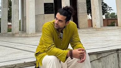 Jubin Nautiyal, the popular singer, sitting outdoors in a yellow kurta, with a contemplative expression,.