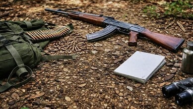 Gun and binoculars on forest ground, symbolising peace efforts in Maoist-affected areas.