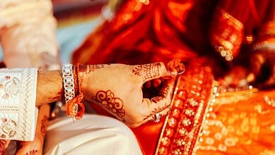 Close-up of a bride's hand with henna and jewelry during a traditional wedding in Telangana.
