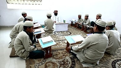 Young students studying Quran in a classroom setting.