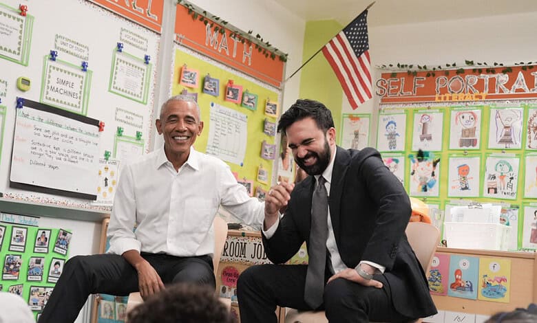 Obama and Mamdani shaking hands in a colourful classroom setting.