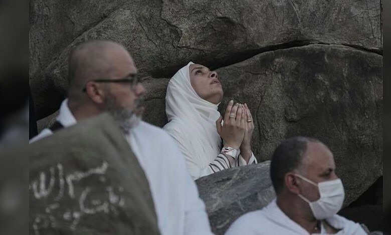 Pilgrims gather on Mount Arafat as a woman raises her hands in prayer during the annual Haj pilgrimage on June 5, 2025.