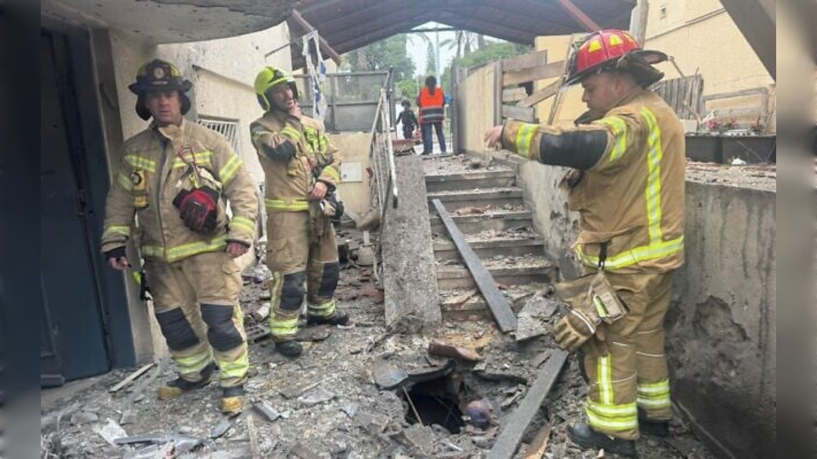 Damage in Rosh Haayin after Iranian missile strike, firefighters inspect debris.