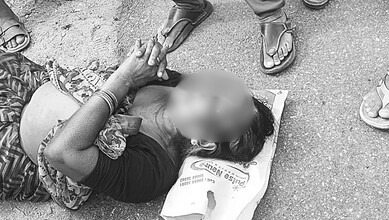 Woman lying on the ground after theft of mangalsutra in Telangana, surrounded by onlookers, during a thef.