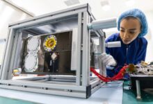 Engineer works on Shams satellite assembly in Saudi laboratory.