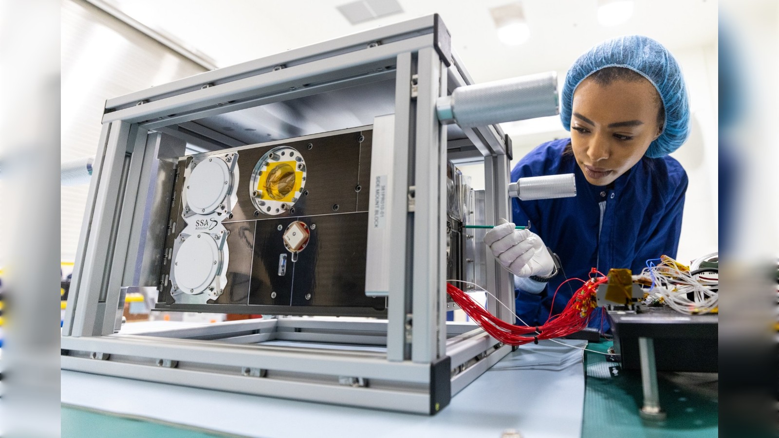 Engineer works on Shams satellite assembly in Saudi laboratory.