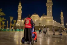 Saudi Red Crescent responder at Quba Mosque in Madinah at night.