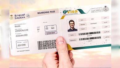 A hand holding a Saudia boarding pass alongside a Saudi Arabia eVisa document for transit travel.m