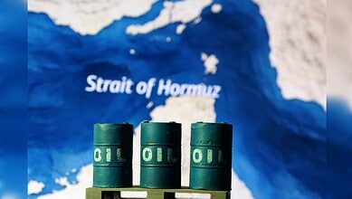 Oil barrels in front of a map highlighting the Strait of Hormuz, reflecting rising oil prices due to geop.