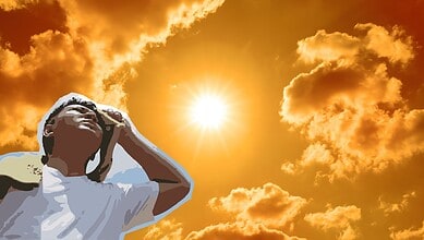 Person gazing at the sunset with clouds in the background, capturing a moment of reflection and awe.