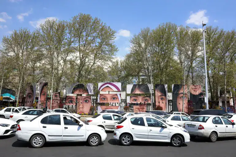 Portraits of children killed in the Minab school strike displayed on Tehran street barriers.