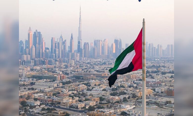 UAE flag flying with Dubai skyline and Burj Khalifa in the background.
