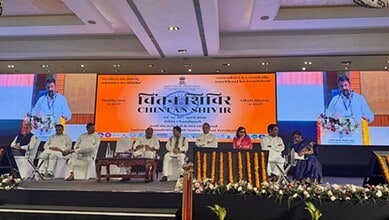 Telangana welfare model showcased at a conference with officials on stage.