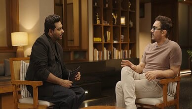 Aamir Khan speaking passionately during an interview about Hindu Goddesses in a modern indoor setting.