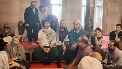 Diverse group of people engaging in a discussion in an elegant indoor setting with wooden walls and large.