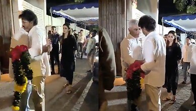 People interacting with a monkey during a festive event at night.