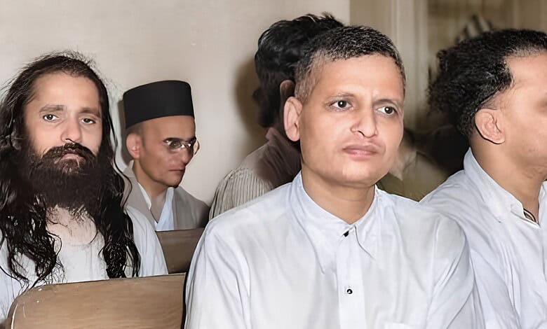 A man in white traditional attire attending a formal event with other individuals in the background.