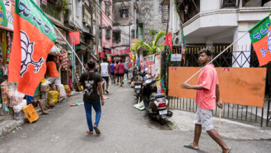 BJP supporters remove TMC party flags and banners from the streets of Tollyganj constituency, a day after the declaration of West Bengal Assembly election results, in Kolkata, Tuesday, May 5, 202