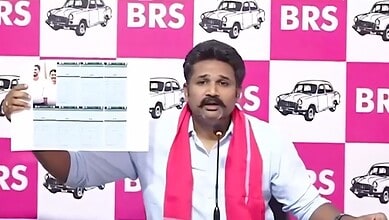A man holding a newspaper in front of a pink and white BRS logo backdrop.