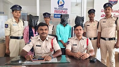 Police officers with two individuals wearing black bags over their heads at Telangana Rising event.