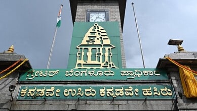 The Siasat Daily logo on a building with a clock tower in Bengaluru, symbolising local governance and civ.