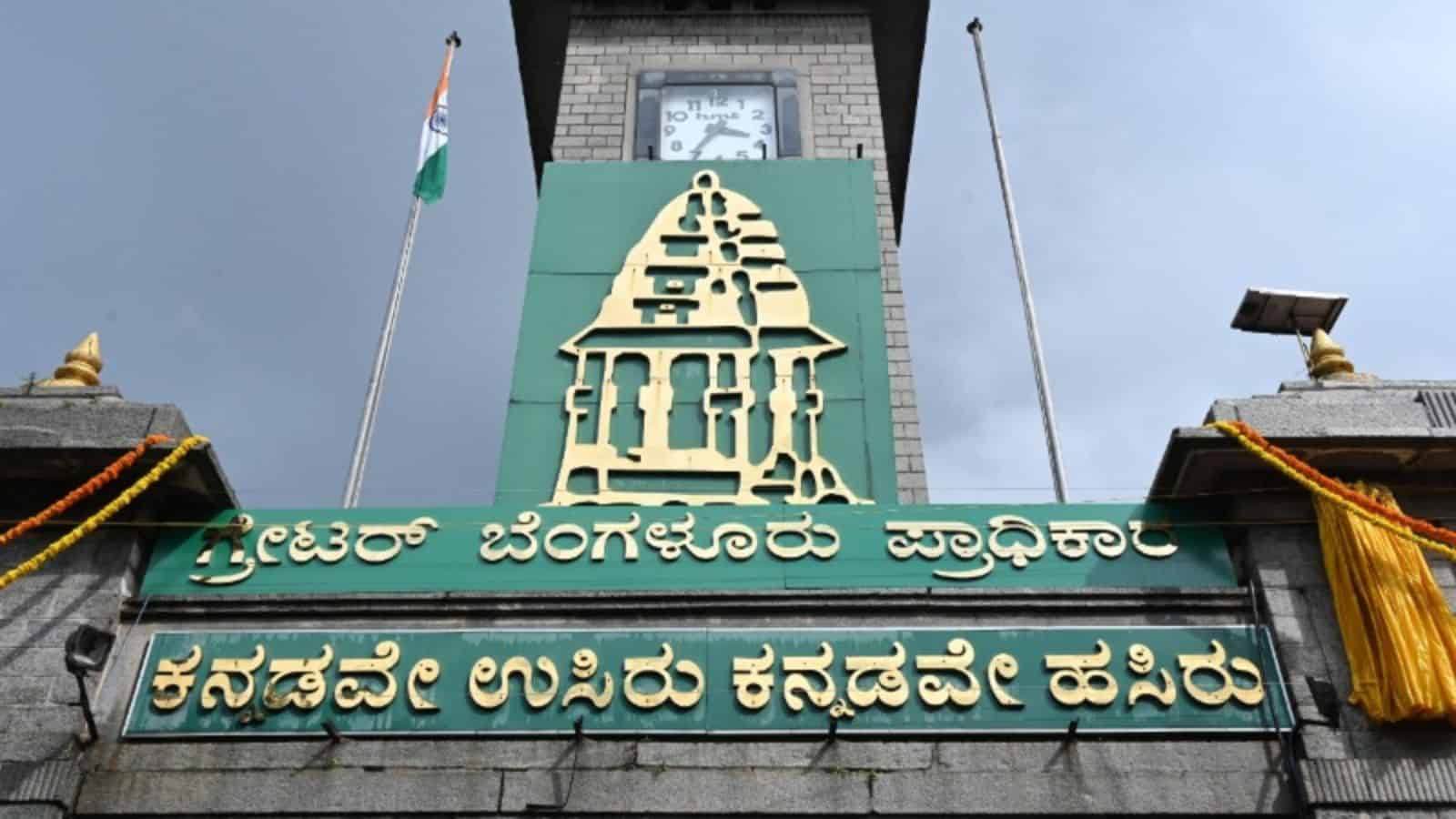 The Siasat Daily logo on a building with a clock tower in Bengaluru, symbolising local governance and civ.