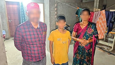 Family members standing together in a laundry area with clothes hanging to dry.